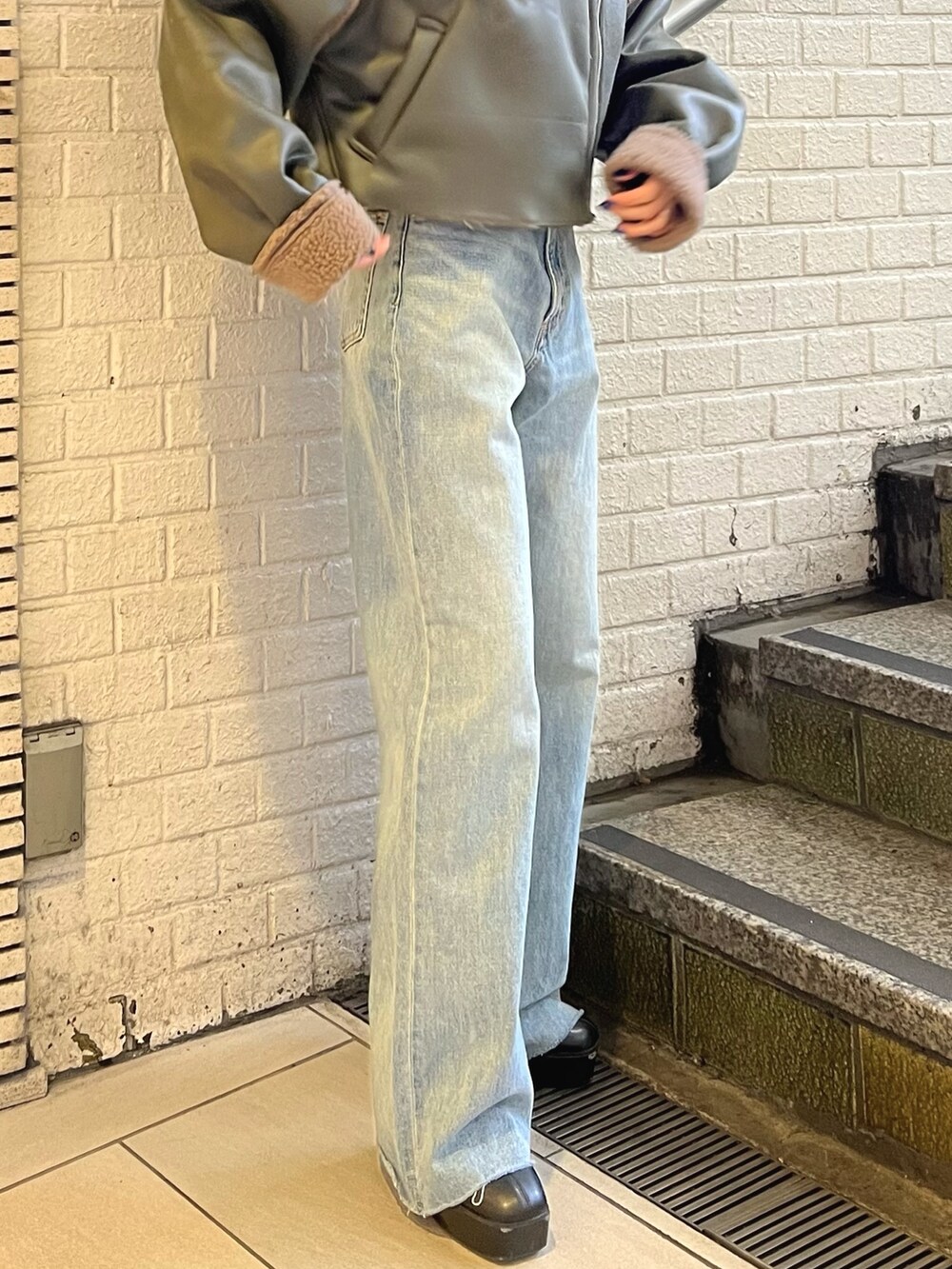 ベージュ系のブルゾン、ブルー系のデニムパンツ、ブラック系のブーツを着用したレディースの冬コーディネートの5枚目の写真