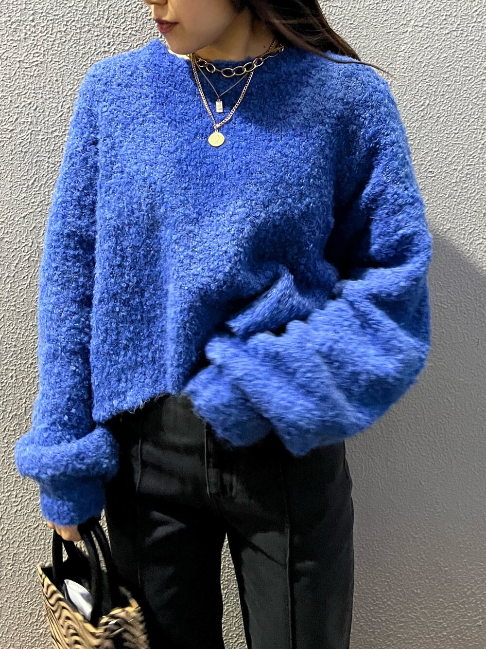 ブルー系のニット/セーター、その他のショルダーバッグ、ブラック系のデニムパンツを着用したレディースの冬コーディネートの6枚目の写真