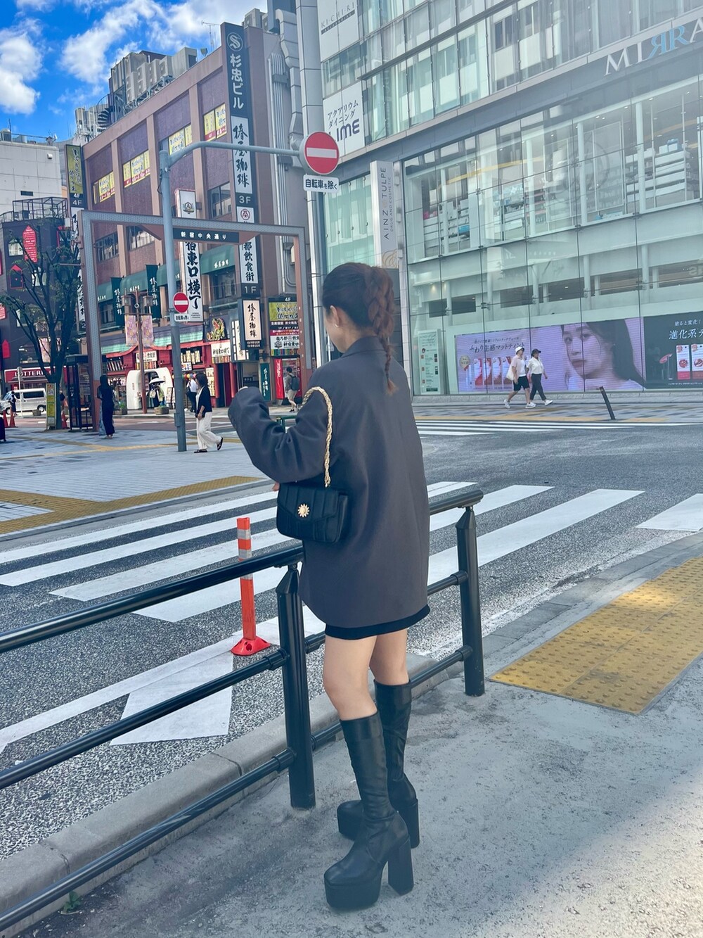 ブラック系のブーツ、ブラック系のショルダーバッグ、ブラック系のスカートを着用したレディースの秋コーディネートの3枚目の写真