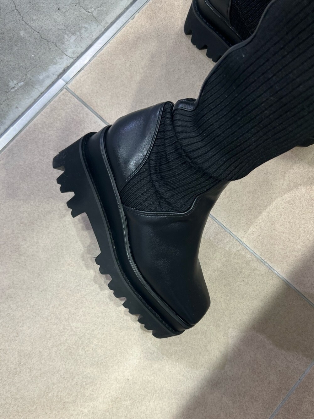 ホワイト系のニット/セーター、ブラック系のその他パンツ、ブラック系のブーツを着用したレディースの秋コーディネートの8枚目の写真