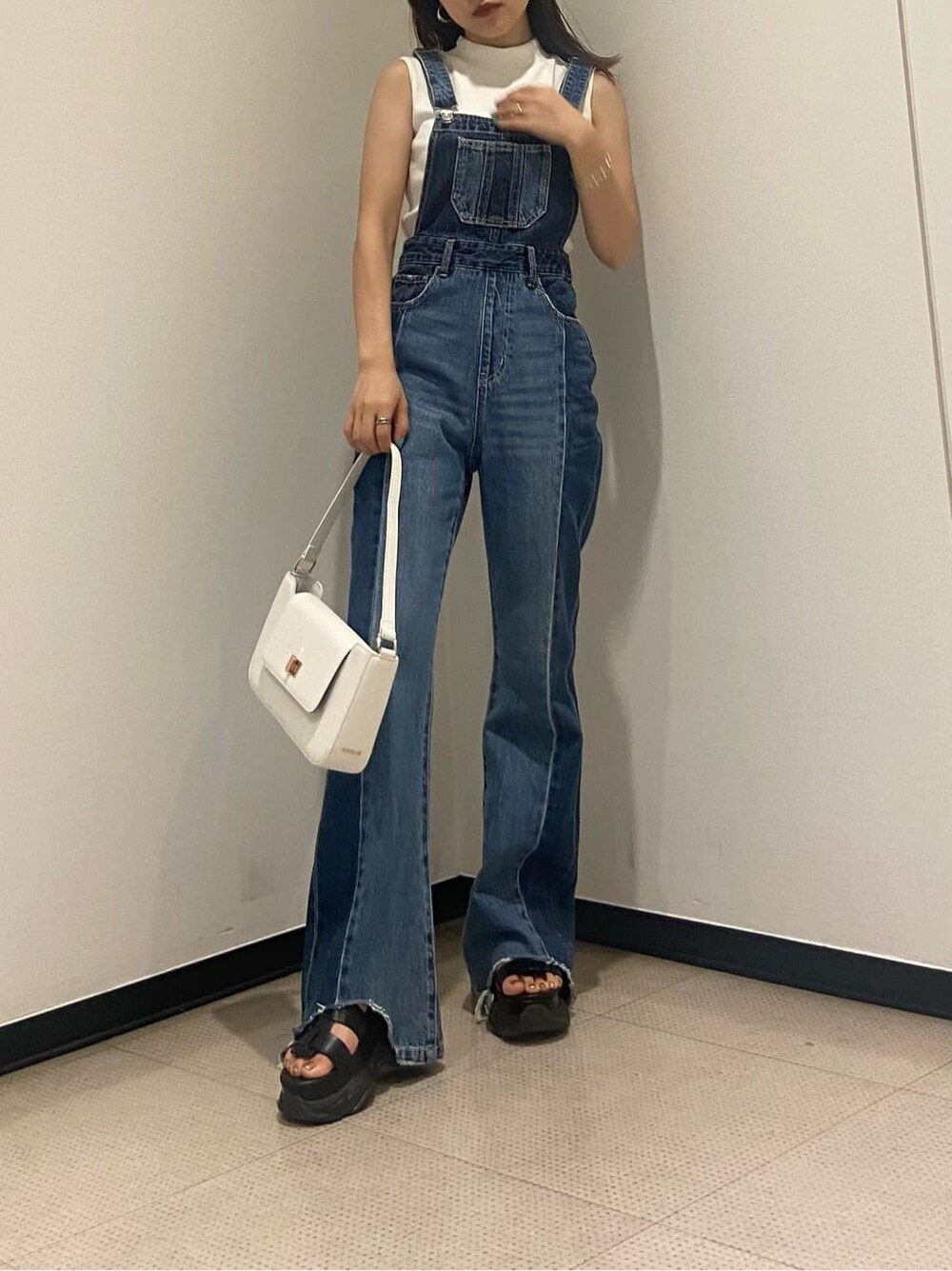 ホワイト系のタンクトップ、ブルー系のサロペット/オーバーオール、ブラック系のサンダルを着用したレディースの夏コーディネートの2枚目の写真