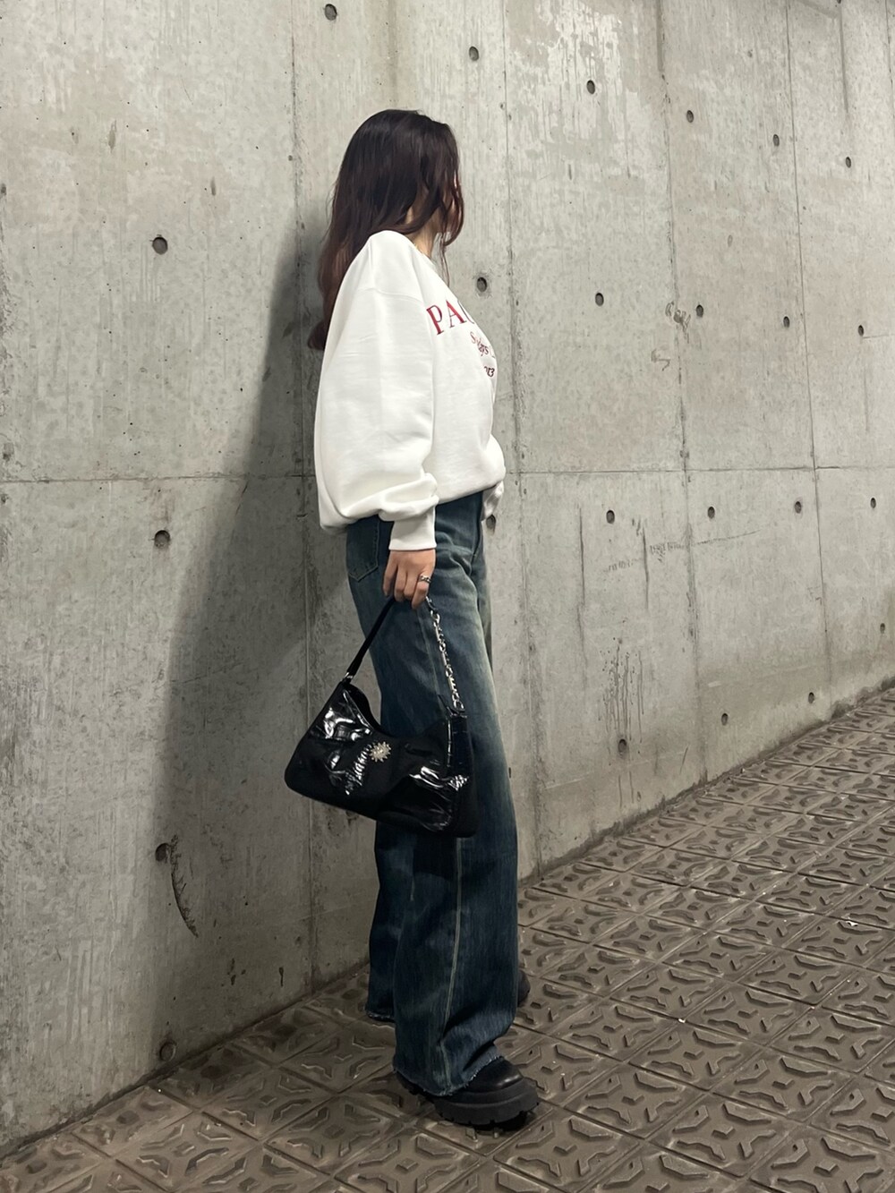 ブルー系のデニムパンツ、ブラック系のブーツ、ブラック系のハンドバッグを着用したレディースの冬コーディネートの2枚目の写真