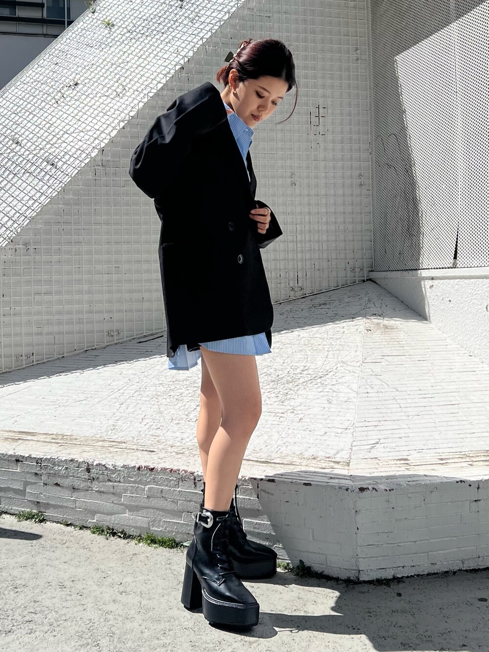 ブラック系のブーツ、ブラック系のテーラードジャケット、ブルー系のシャツ/ブラウスを着用したレディースの春コーディネートの4枚目の写真