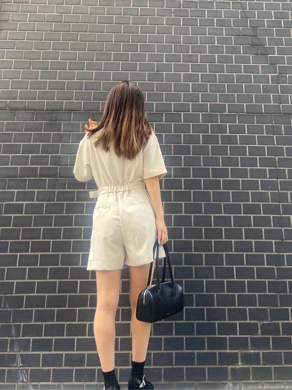 ブラック系のボストンバッグ、ブラック系のキャミソール、ホワイト系のつなぎ/オールインワンを着用したレディースの春コーディネートの4枚目の写真