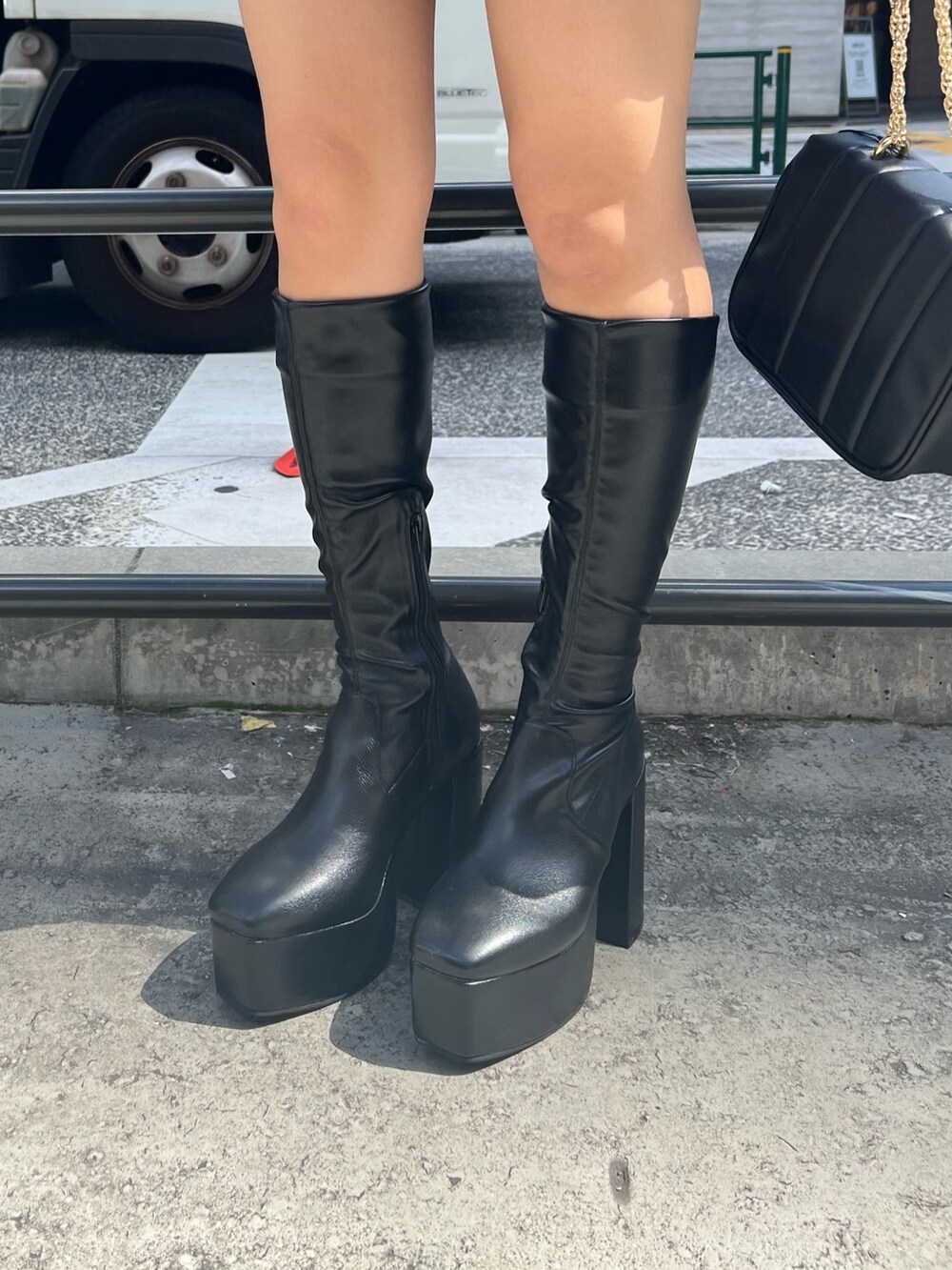 ブラック系のブーツ、ブラック系のショルダーバッグ、ブラック系のスカートを着用したレディースの秋コーディネートの9枚目の写真