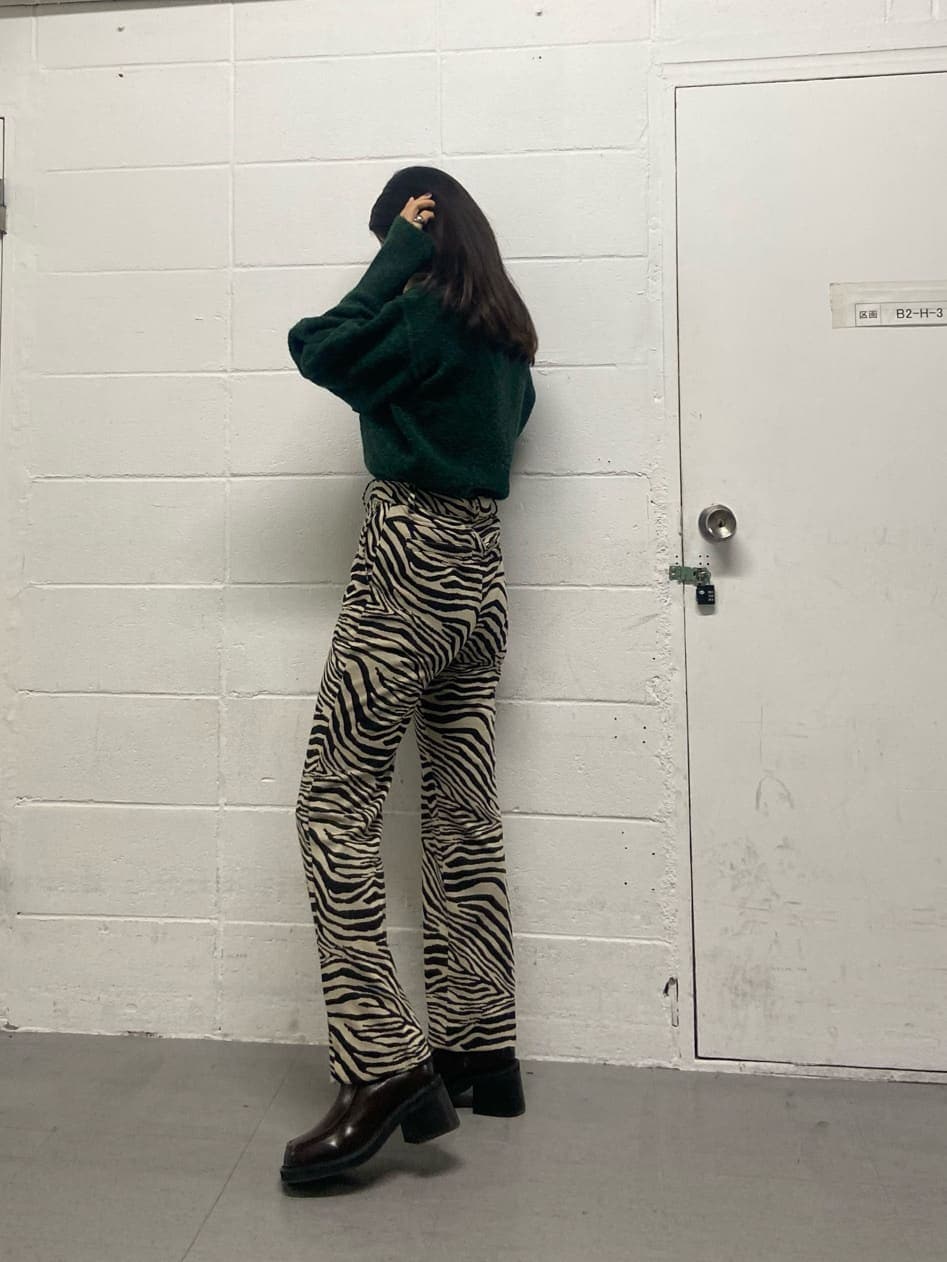 ホワイト系のブーツ、その他のその他パンツ、グリーン系のニット/セーターを着用したレディースの冬コーディネートの2枚目の写真