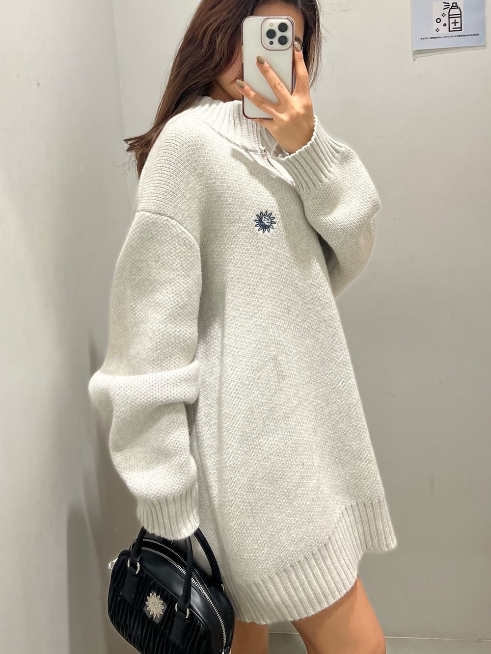 グレー系のニット/セーター、ブラック系のショルダーバッグ、ブラック系のブーツを着用したレディースの冬コーディネートの5枚目の写真