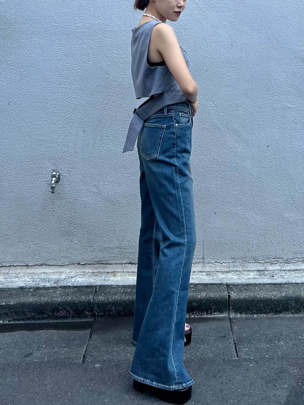 ブルー系のデニムパンツ、グレー系のシャツ/ブラウス、ブラック系のショルダーバッグを着用したレディースの夏コーディネートの6枚目の写真