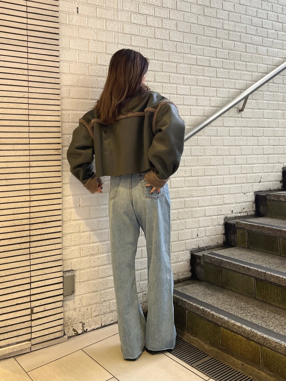 ベージュ系のブルゾン、ブルー系のデニムパンツ、ブラック系のブーツを着用したレディースの冬コーディネートの3枚目の写真