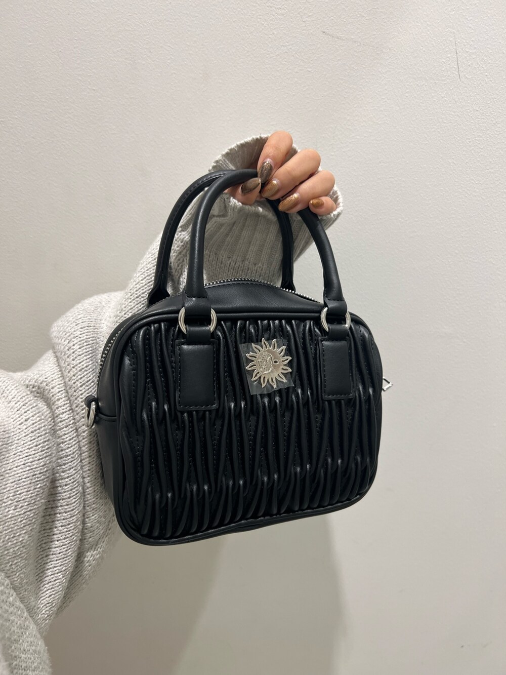 グレー系のニット/セーター、ブラック系のショルダーバッグ、ブラック系のブーツを着用したレディースの冬コーディネートの7枚目の写真