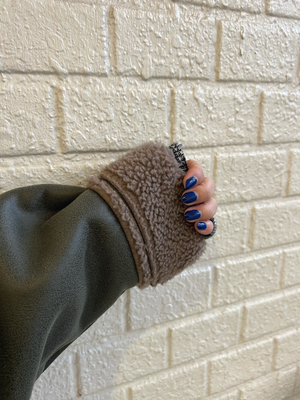 ベージュ系のブルゾン、ブルー系のデニムパンツ、ブラック系のブーツを着用したレディースの冬コーディネートの7枚目の写真