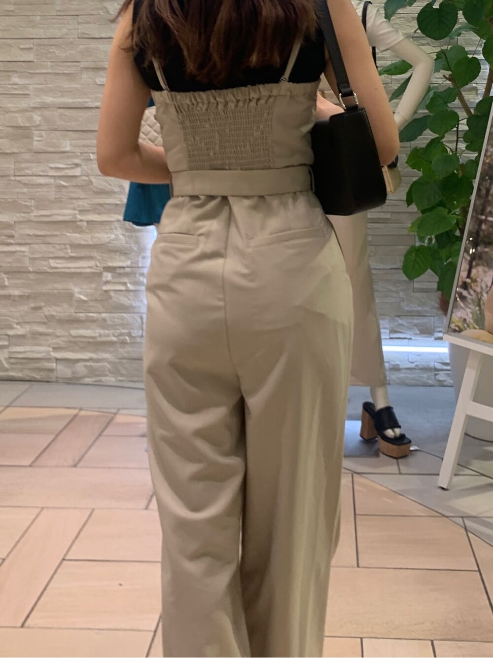 ブラック系のタンクトップ、ホワイト系のサロペット/オーバーオール、ブラック系のショルダーバッグを着用したレディースの夏コーディネートの5枚目の写真