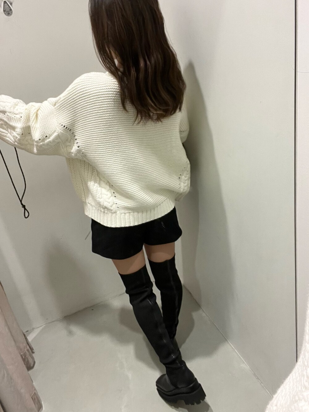 ホワイト系のニット/セーター、ブラック系のその他パンツ、ブラック系のブーツを着用したレディースの秋コーディネートの5枚目の写真