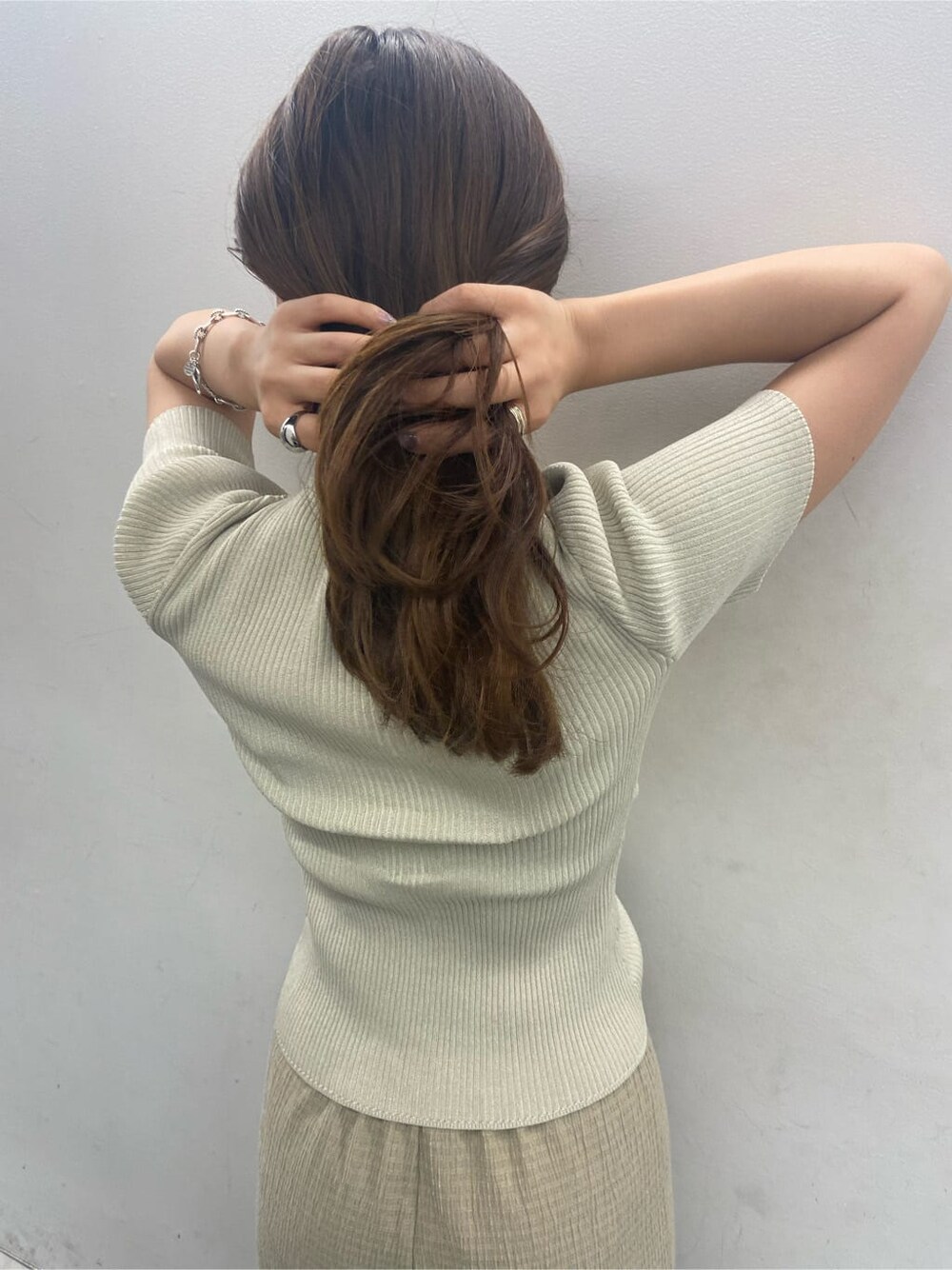 ホワイト系のニット/セーター、ブラック系のサンダル、ブラック系のハンドバッグを着用したレディースの夏コーディネートの3枚目の写真