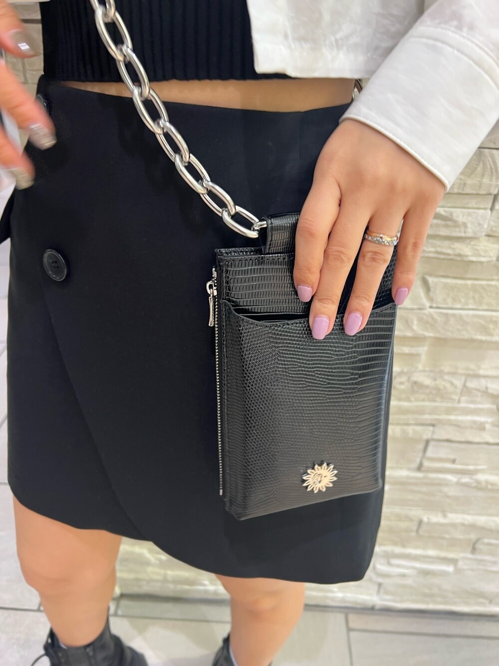 ブラック系のブーツ、ブラック系のスカート、ブラック系のカーディガン/ボレロを着用したレディースの春コーディネートの6枚目の写真