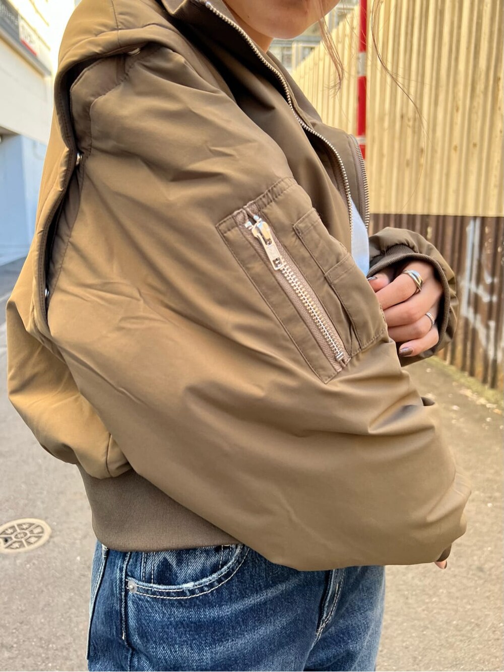 ブラック系のブーツ、ホワイト系のTシャツ/カットソー、ベージュ系のMA-1を着用したレディースの秋コーディネートの7枚目の写真