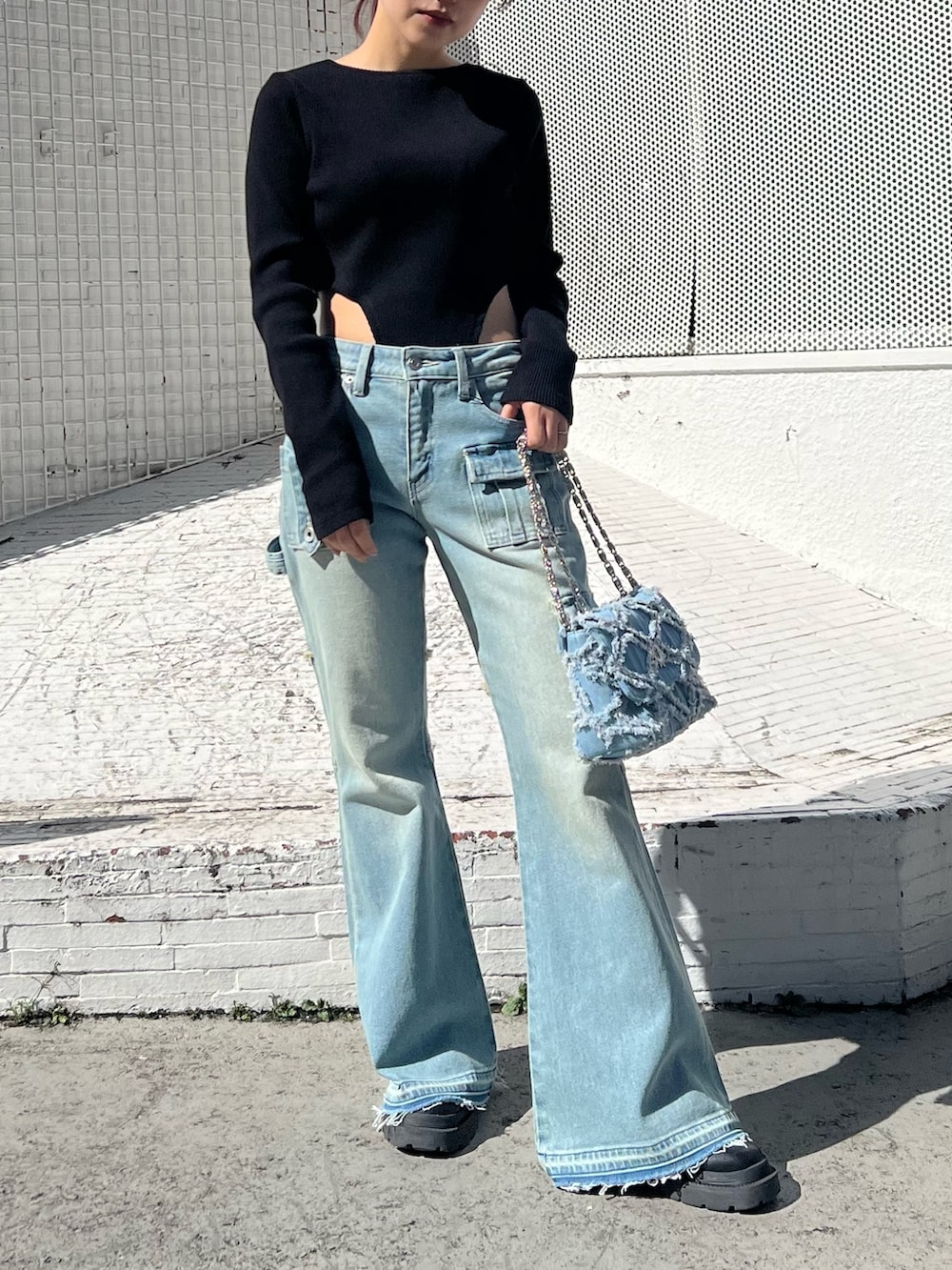 ブルー系のデニムパンツ、ブルー系のショルダーバッグ、ブラック系のTシャツ/カットソーを着用したレディースの冬コーディネートの2枚目の写真