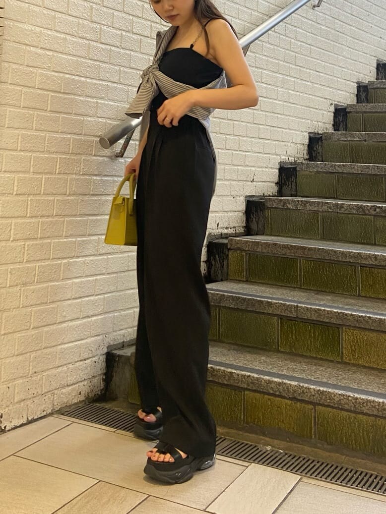 ブラック系のスラックス、ブラック系のサンダル、ブラック系のワンピースを着用したレディースの春コーディネートの3枚目の写真