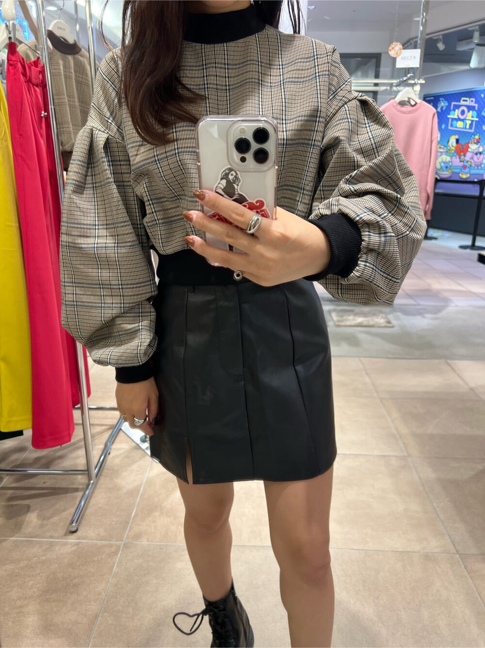 ブラック系のブーツ、ブラック系のシャツ/ブラウス、ブラック系のスカートを着用したレディースの秋コーディネートの3枚目の写真