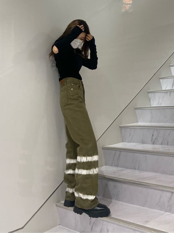 ブラック系のブーツ、ブラック系のTシャツ/カットソー、ベージュ系のデニムパンツを着用したレディースの夏コーディネートの3枚目の写真