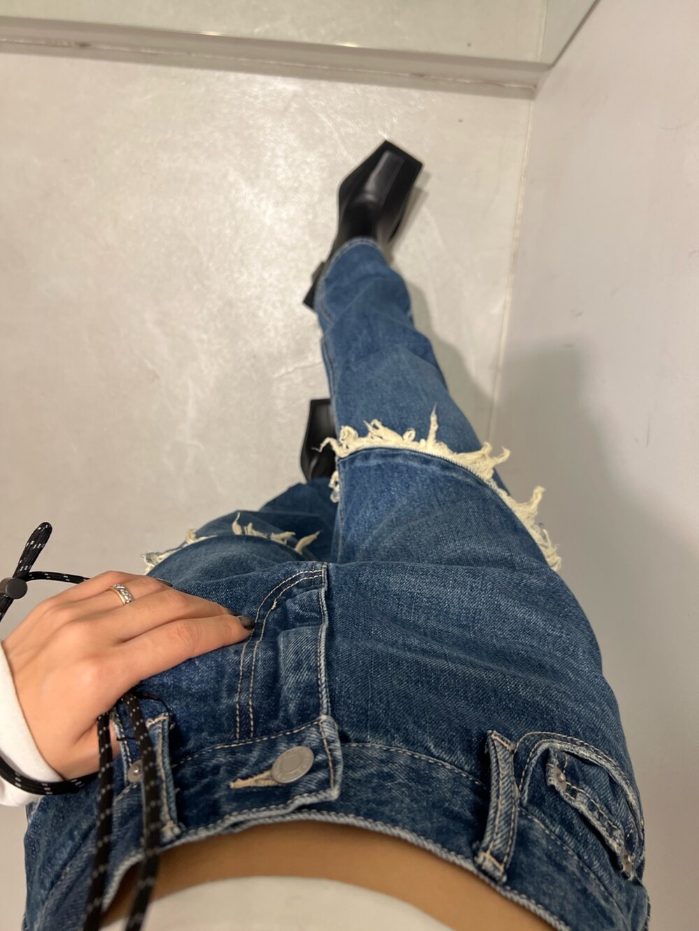 ブルー系のデニムパンツ、ホワイト系のショルダーバッグ、ホワイト系のTシャツ/カットソーを着用したレディースの秋コーディネートの5枚目の写真