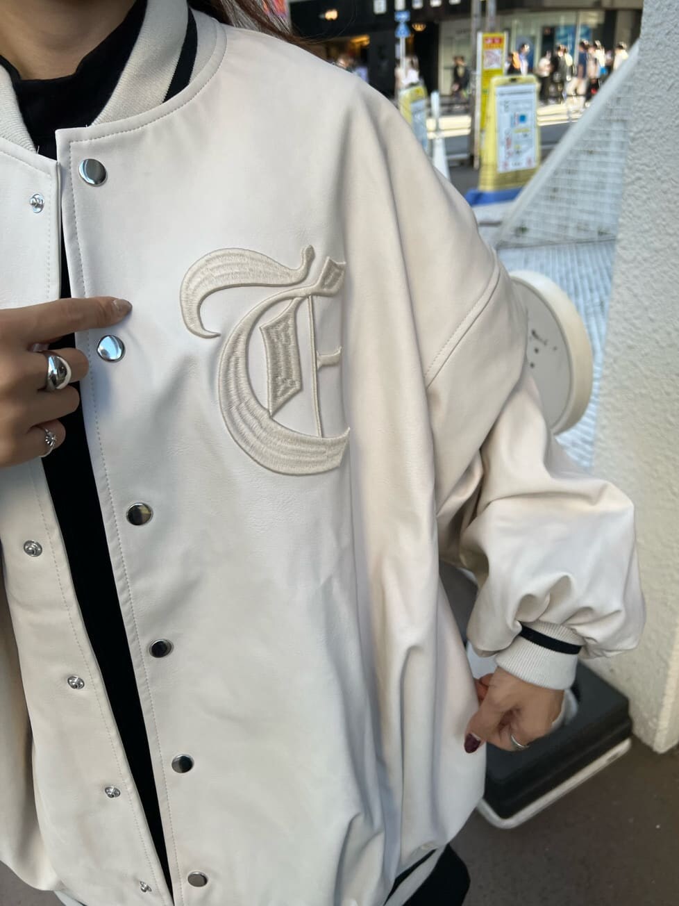 ブラック系のブーツ、ブラック系のワンピース、ホワイト系のスタジャンを着用したレディースの秋コーディネートの8枚目の写真