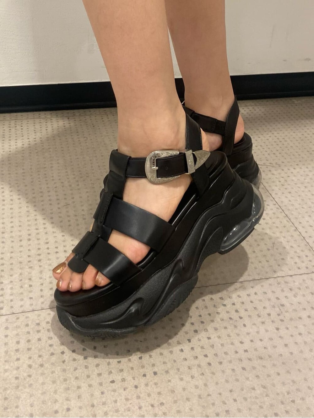 ブラック系のサンダル、ブラック系のタンクトップ、ベージュ系のデニムパンツを着用したレディースの夏コーディネートの7枚目の写真