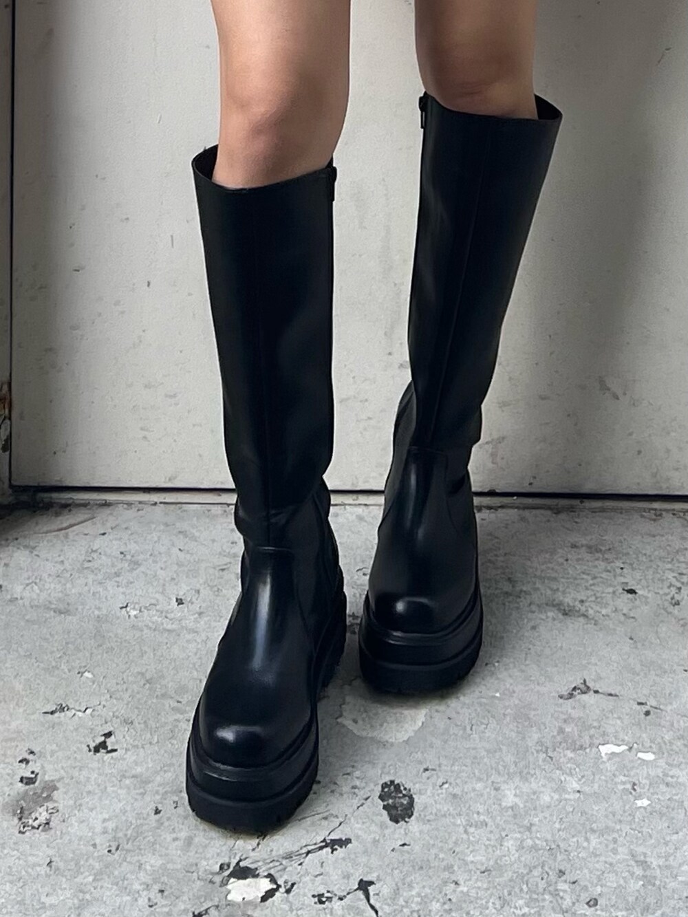 レッド系のニット/セーター、ブラック系のブーツを着用したレディースの冬コーディネートの7枚目の写真