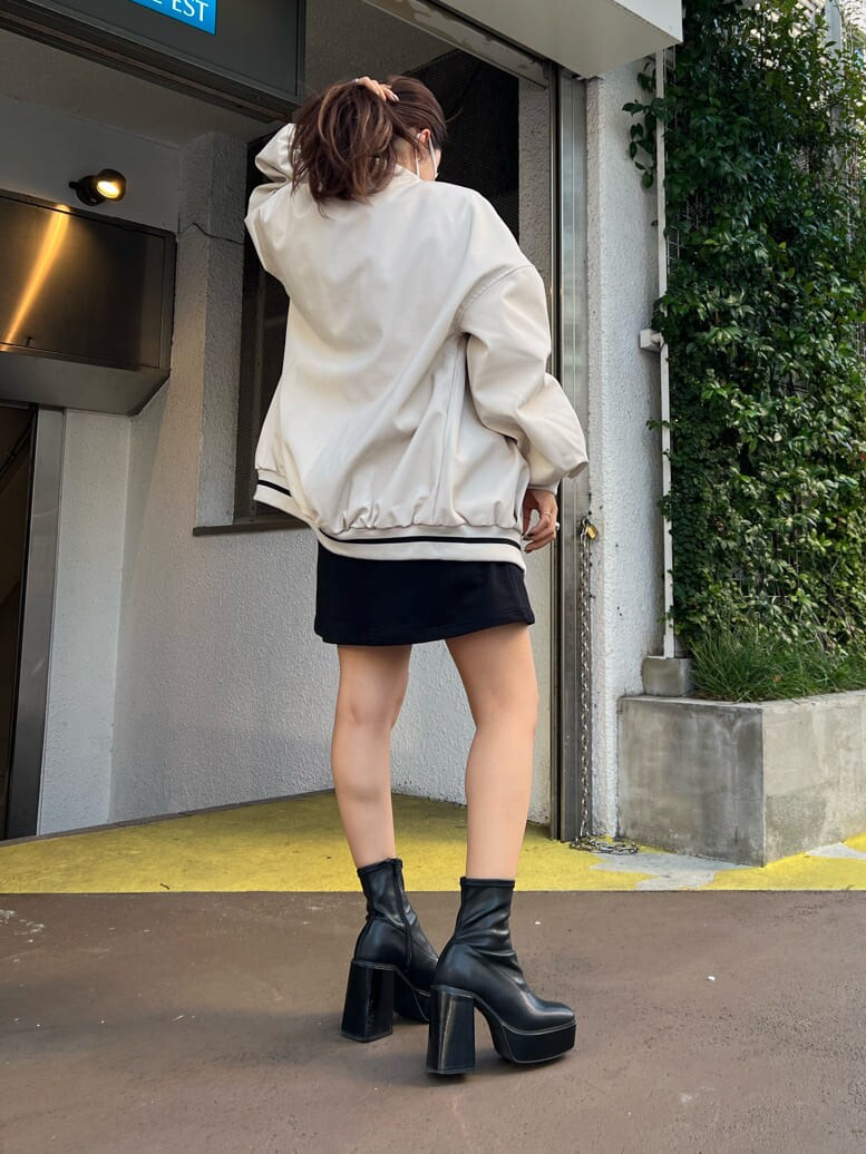 ブラック系のブーツ、ブラック系のワンピース、ホワイト系のスタジャンを着用したレディースの秋コーディネートの7枚目の写真