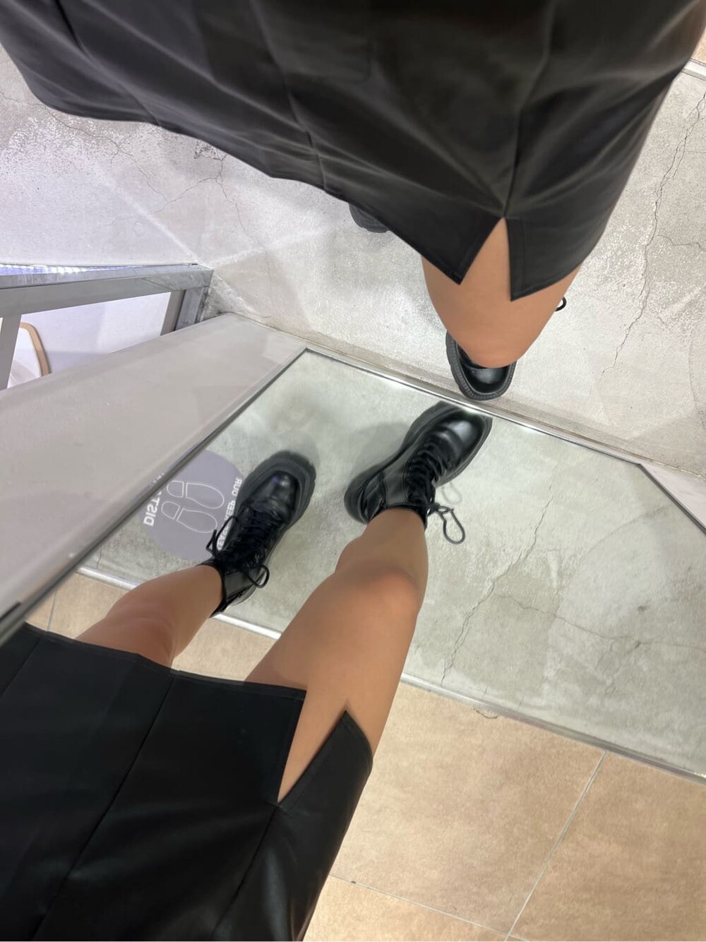 ブラック系のブーツ、ブラック系のシャツ/ブラウス、ブラック系のスカートを着用したレディースの秋コーディネートの6枚目の写真