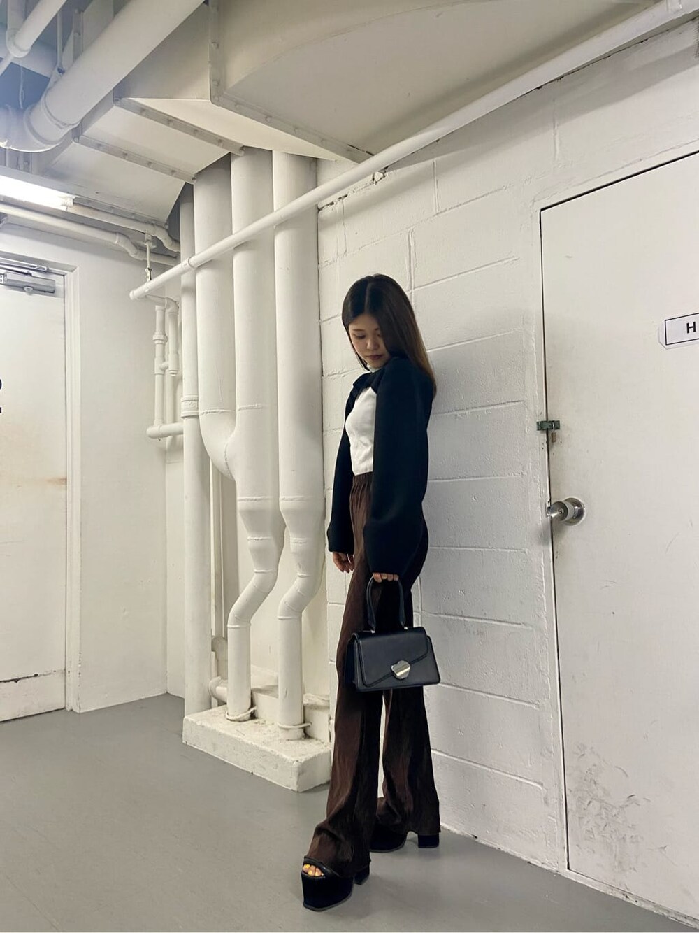 ブラック系のハンドバッグ、ブラック系のTシャツ/カットソー、ホワイト系のTシャツ/カットソーを着用したレディースの夏コーディネートの2枚目の写真