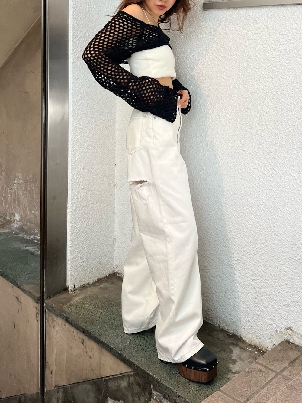 ホワイト系のデニムパンツ、ブラック系のサンダル、ブラック系のニット/セーターを着用したレディースの春コーディネートの3枚目の写真