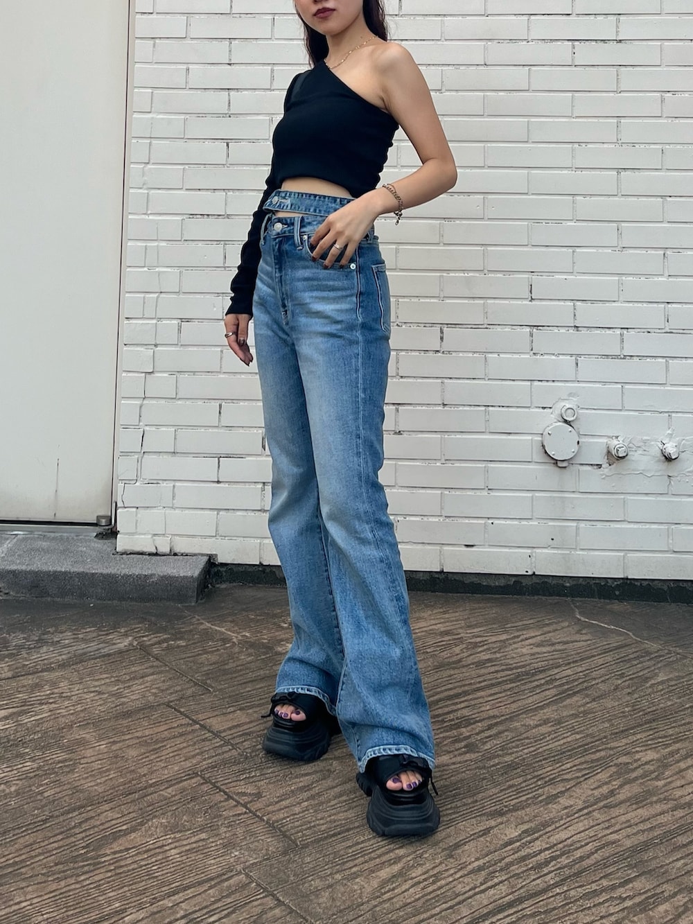 ブラック系のTシャツ/カットソー、ブラック系のサンダル、ブルー系のデニムパンツを着用したレディースの夏コーディネートの3枚目の写真