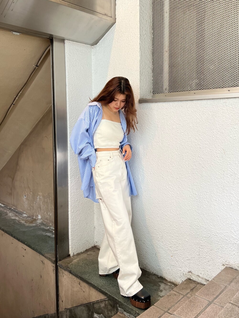 ホワイト系のデニムパンツ、ホワイト系のニット/セーター、ブルー系のシャツ/ブラウスを着用したレディースの春コーディネートの4枚目の写真