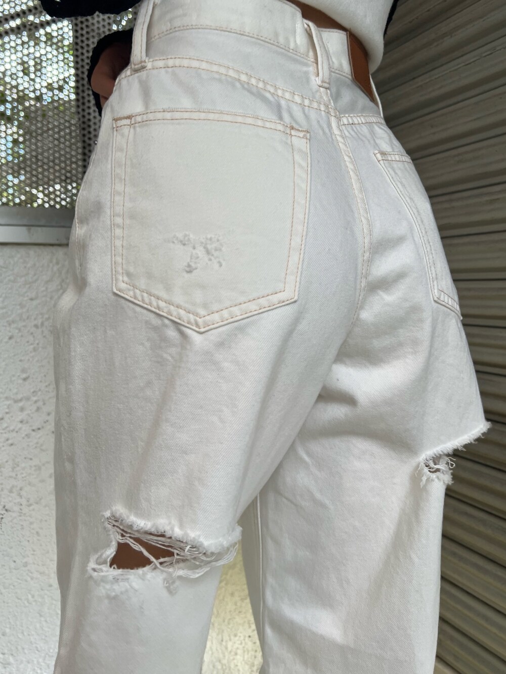 ホワイト系のデニムパンツ、ホワイト系のニット/セーター、ブルー系のシャツ/ブラウスを着用したレディースの春コーディネートの7枚目の写真