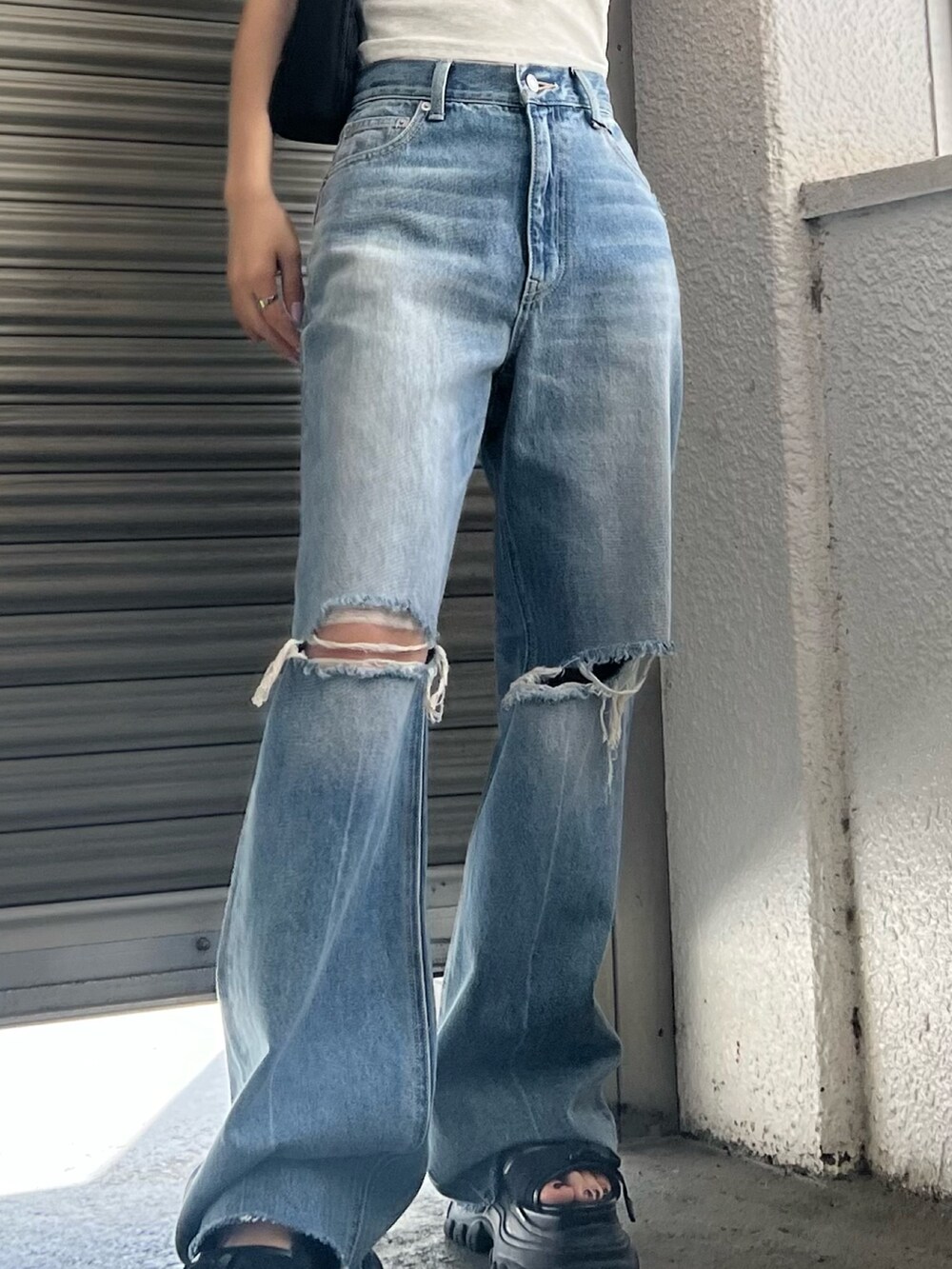 ブルー系のデニムパンツ、ブラック系のサンダル、グリーン系のニット/セーターを着用したレディースの夏コーディネートの6枚目の写真