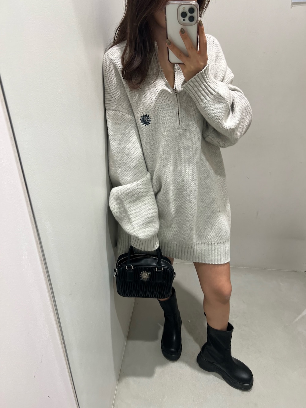 グレー系のニット/セーター、ブラック系のショルダーバッグ、ブラック系のブーツを着用したレディースの冬コーディネートの3枚目の写真