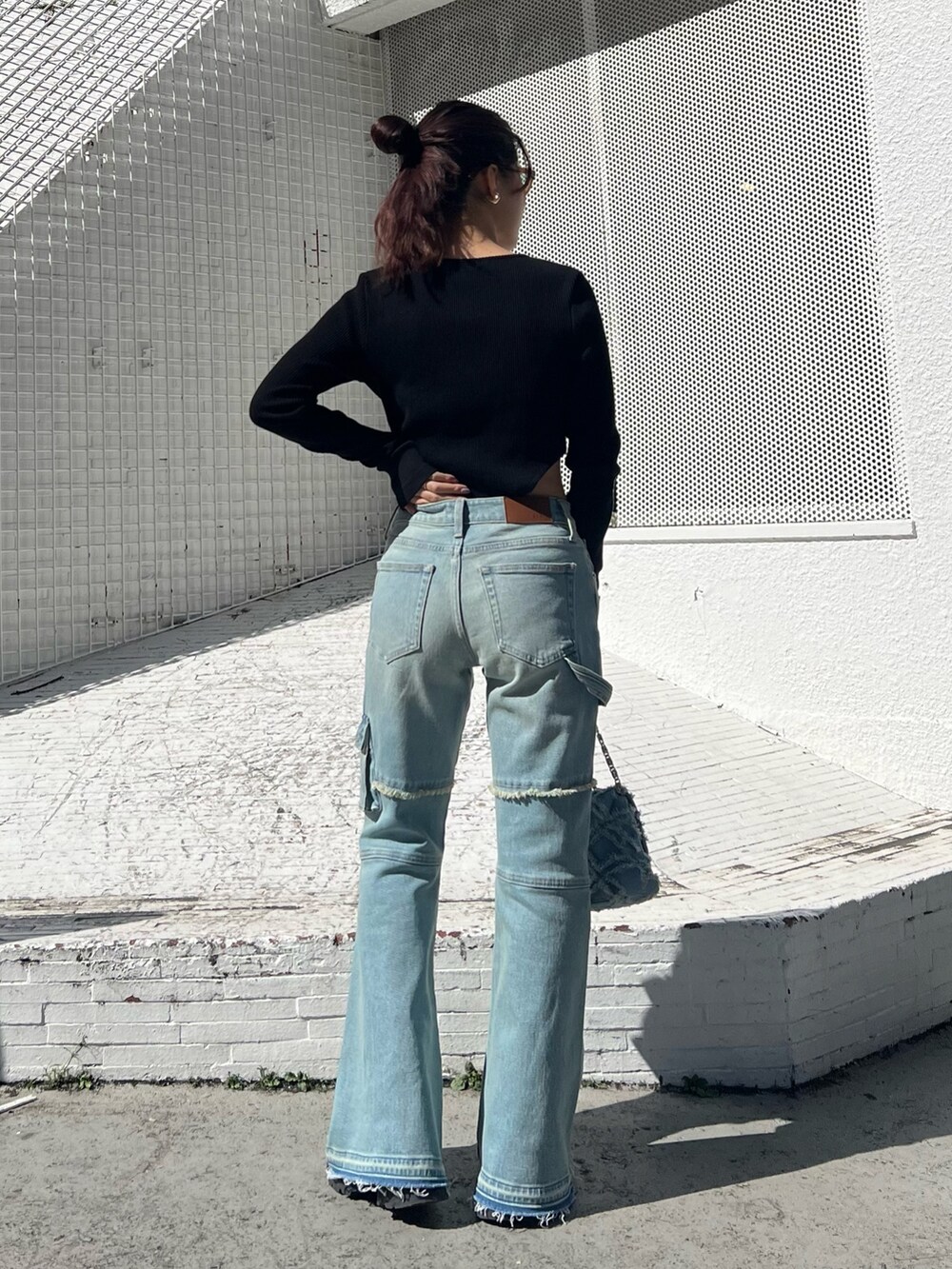 ブルー系のデニムパンツ、ブルー系のショルダーバッグ、ブラック系のTシャツ/カットソーを着用したレディースの冬コーディネートの5枚目の写真