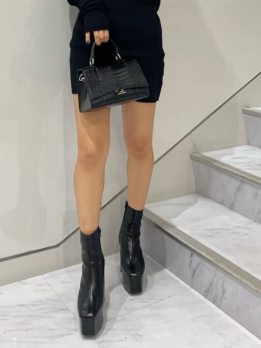 ブラック系のワンピース、ブラック系のブーツ、ブラック系のショルダーバッグを着用したレディースの秋コーディネートの2枚目の写真