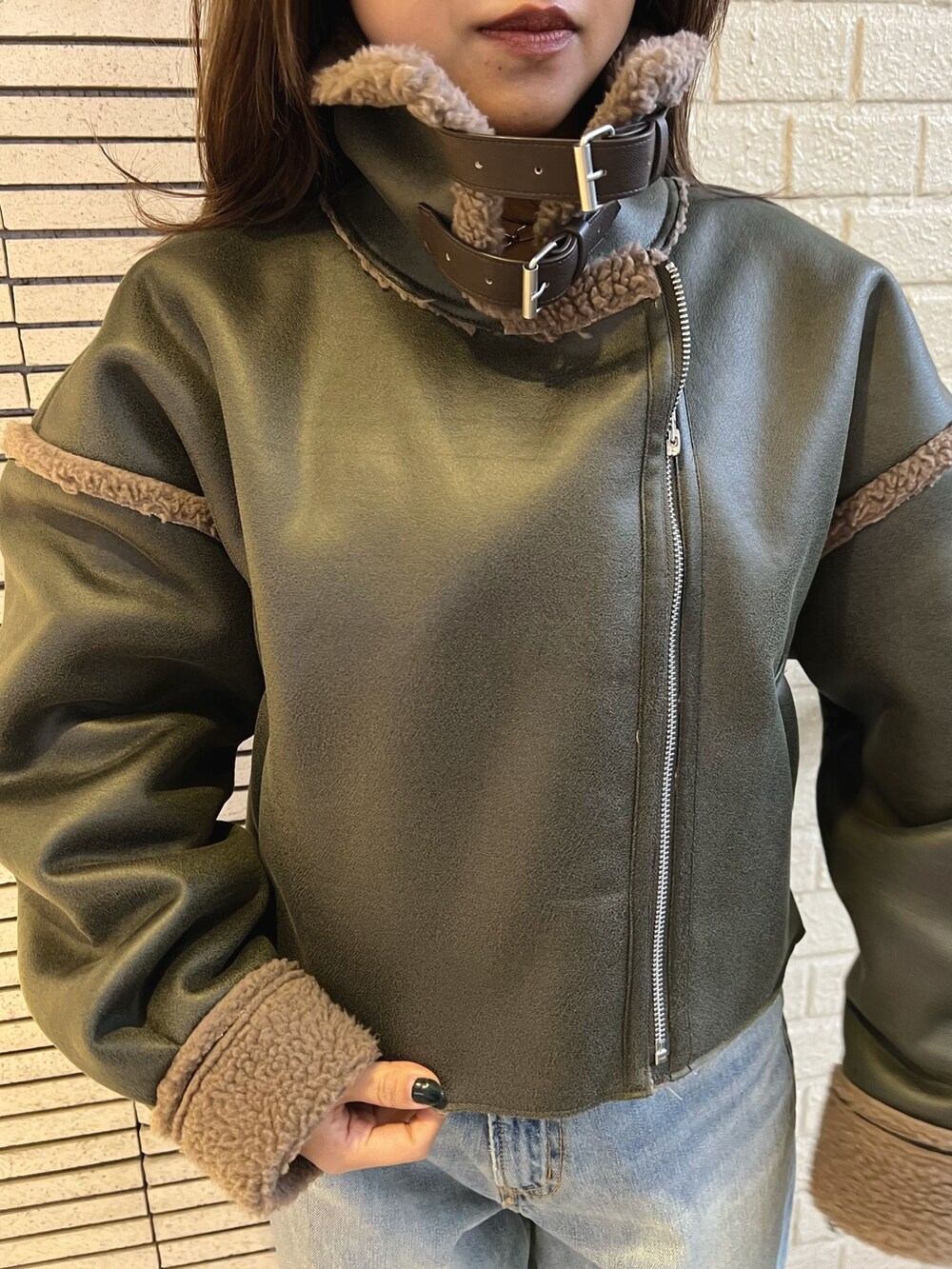 ベージュ系のブルゾン、ブルー系のデニムパンツ、ブラック系のブーツを着用したレディースの冬コーディネートの6枚目の写真