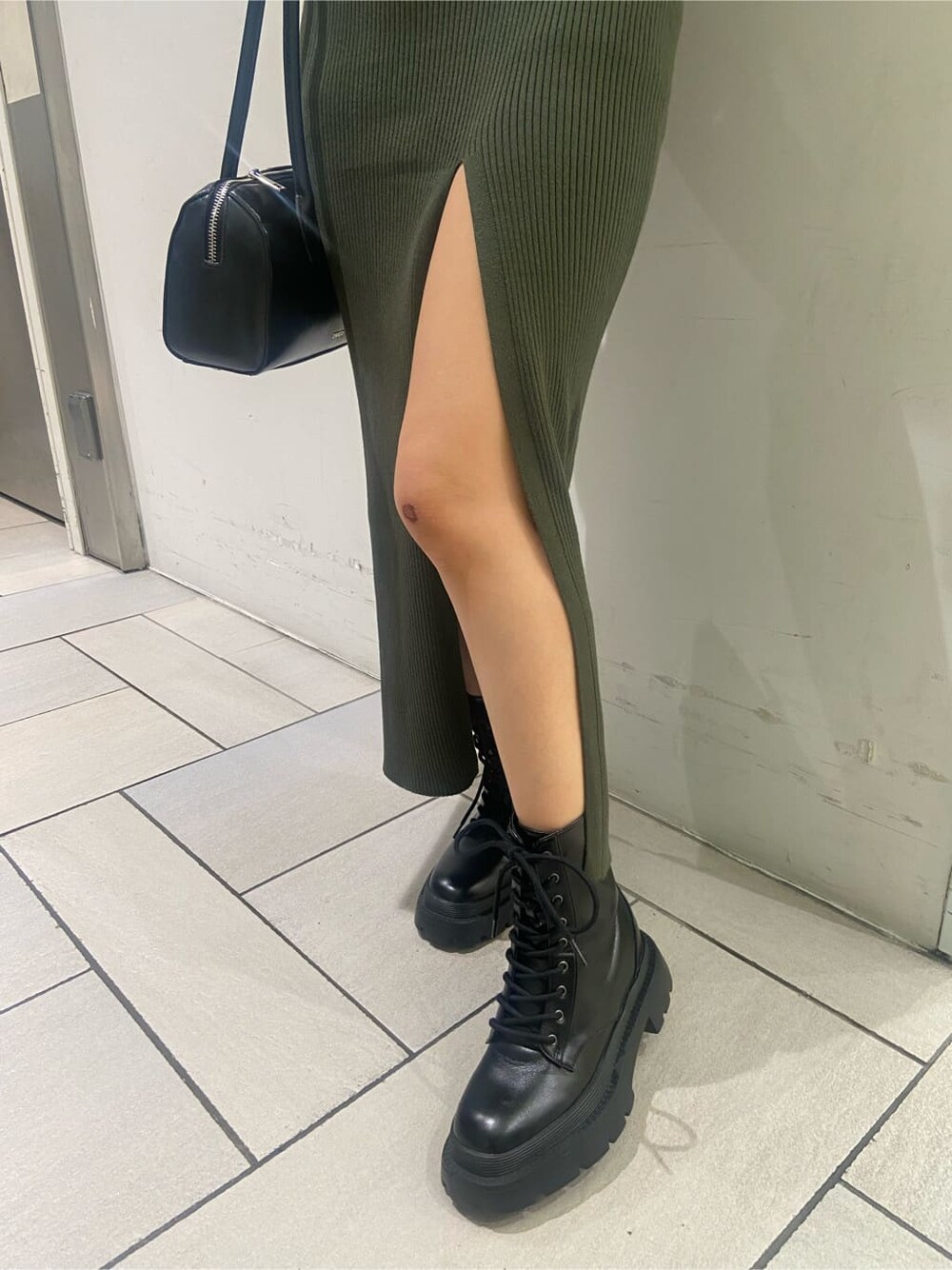 ブラック系のブーツ、ベージュ系のワンピース、ゴールド系のネックレスを着用したレディースの夏コーディネートの8枚目の写真