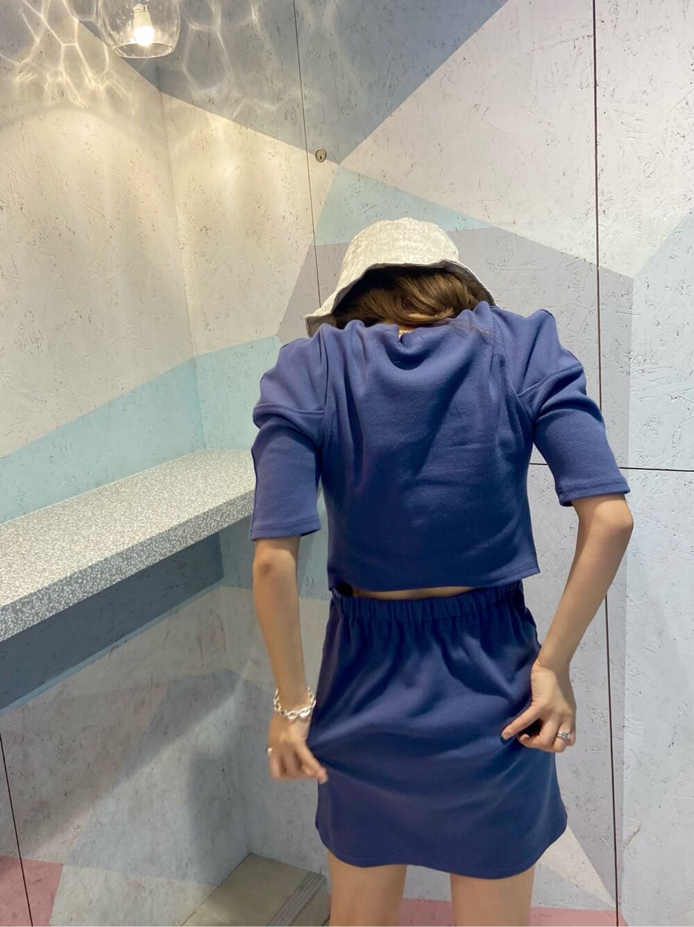 パープル系のワンピース、ホワイト系のハットを着用したレディースの夏コーディネートの3枚目の写真