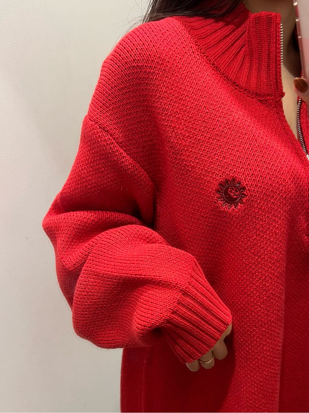 ブラック系のブーツ、レッド系のニット/セーター、ブラック系のスカートを着用したレディースの秋コーディネートの4枚目の写真