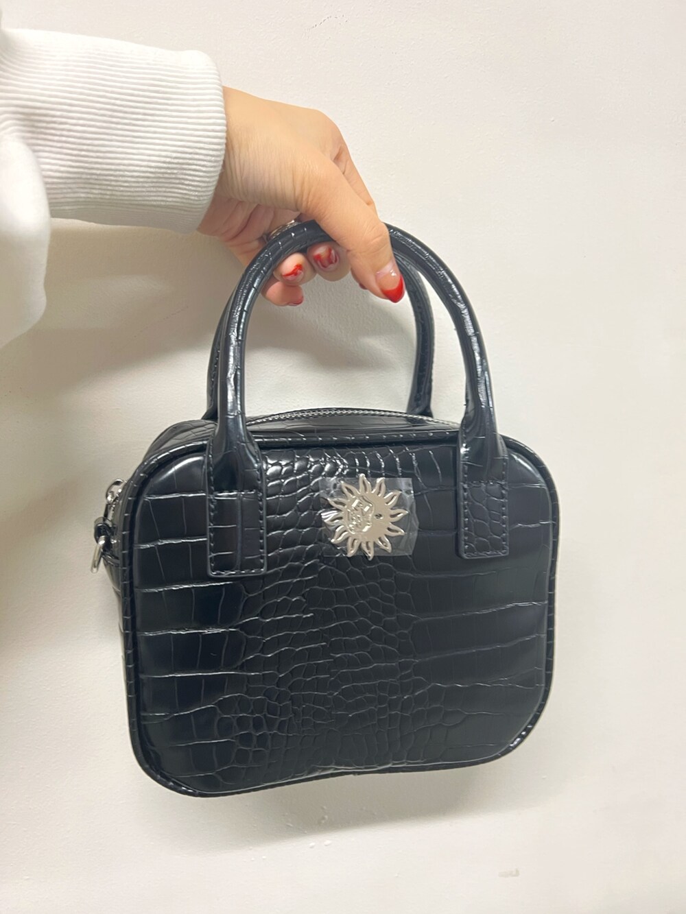 ブラック系のスラックス、ブラック系のショルダーバッグ、ホワイト系のスウェットを着用したレディースの冬コーディネートの8枚目の写真