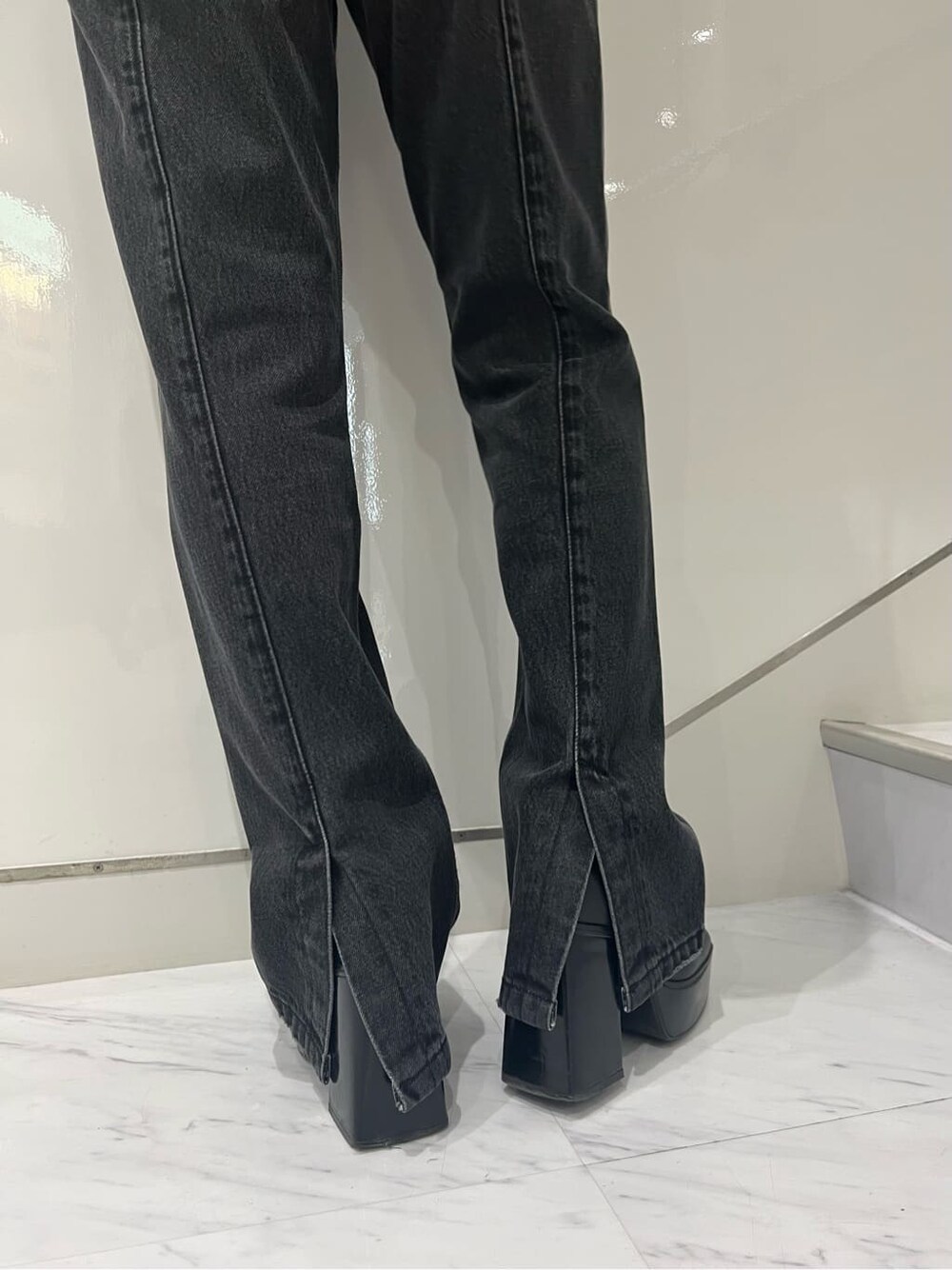 ブラック系のブーツ、ブラック系のデニムパンツ、ブルー系のニット/セーターを着用したレディースの秋コーディネートの7枚目の写真