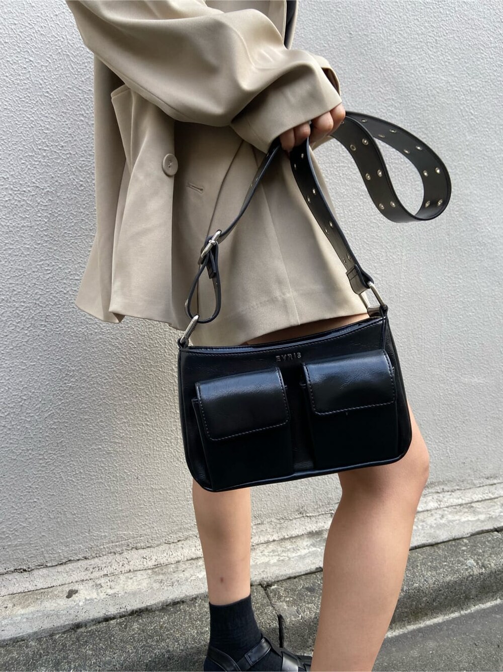 ブラック系のショルダーバッグ、ブラック系のTシャツ/カットソー、ベージュ系のスカートを着用したレディースの春コーディネートの6枚目の写真