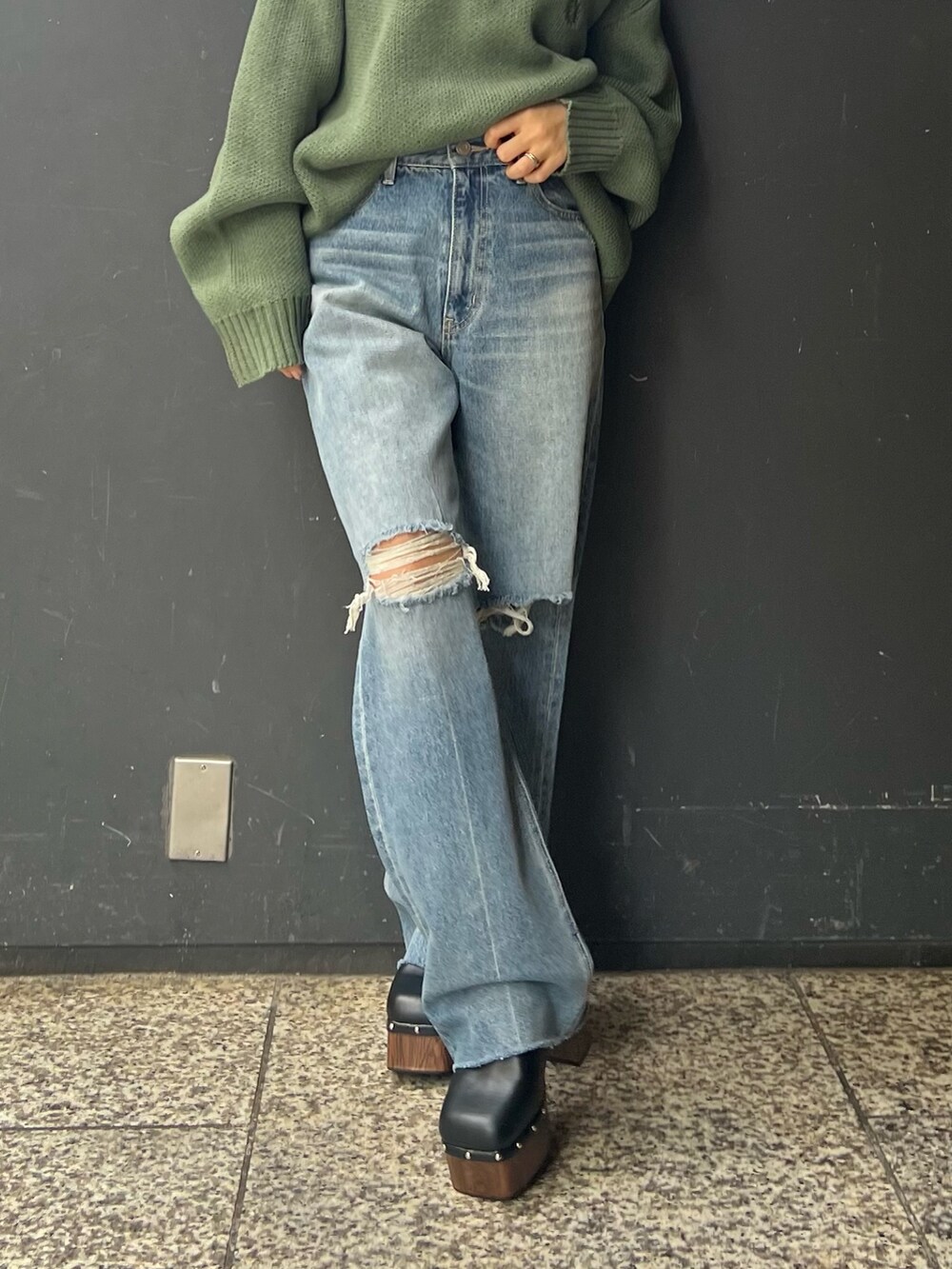 ブルー系のデニムパンツ、ブラック系のサンダル、グリーン系のニット/セーターを着用したレディースの夏コーディネートの2枚目の写真