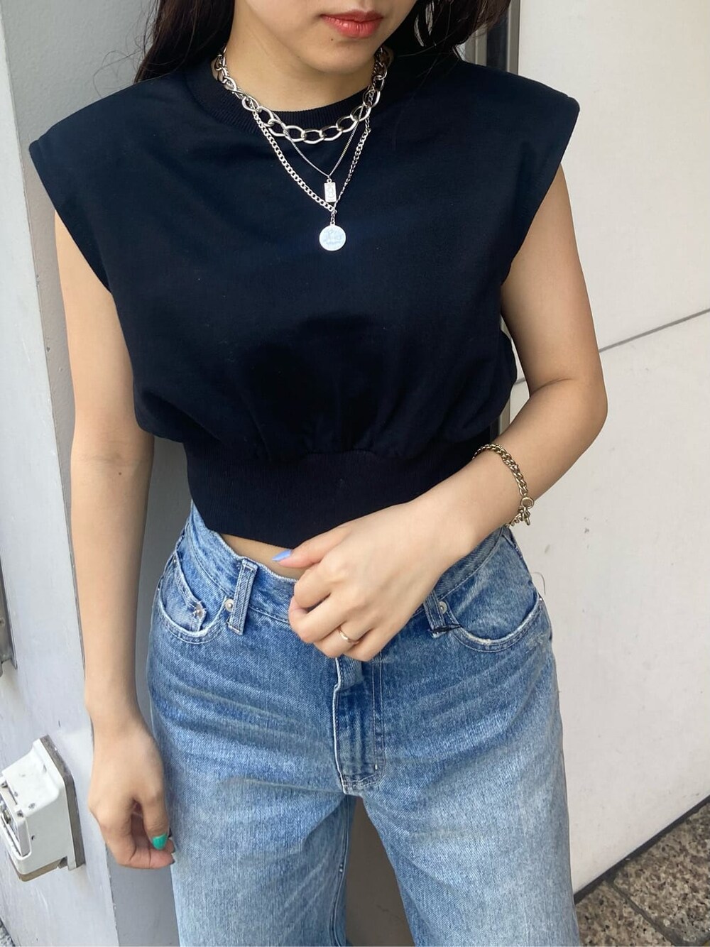 ブラック系のサンダル、ブラック系のTシャツ/カットソー、ブルー系のデニムパンツを着用したレディースの夏コーディネートの3枚目の写真