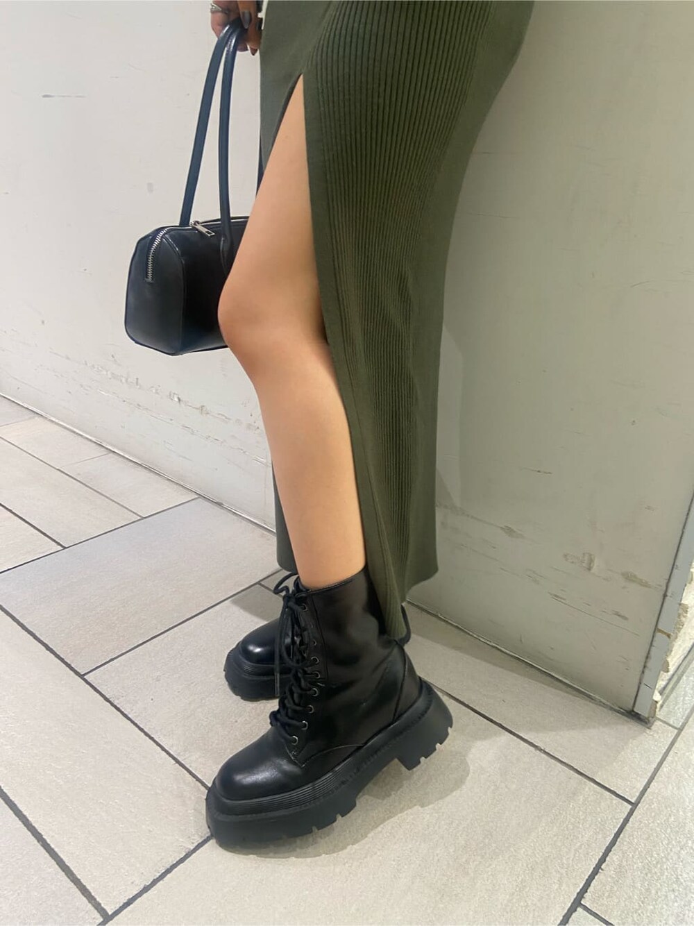 ブラック系のブーツ、ベージュ系のワンピース、ゴールド系のネックレスを着用したレディースの夏コーディネートの9枚目の写真