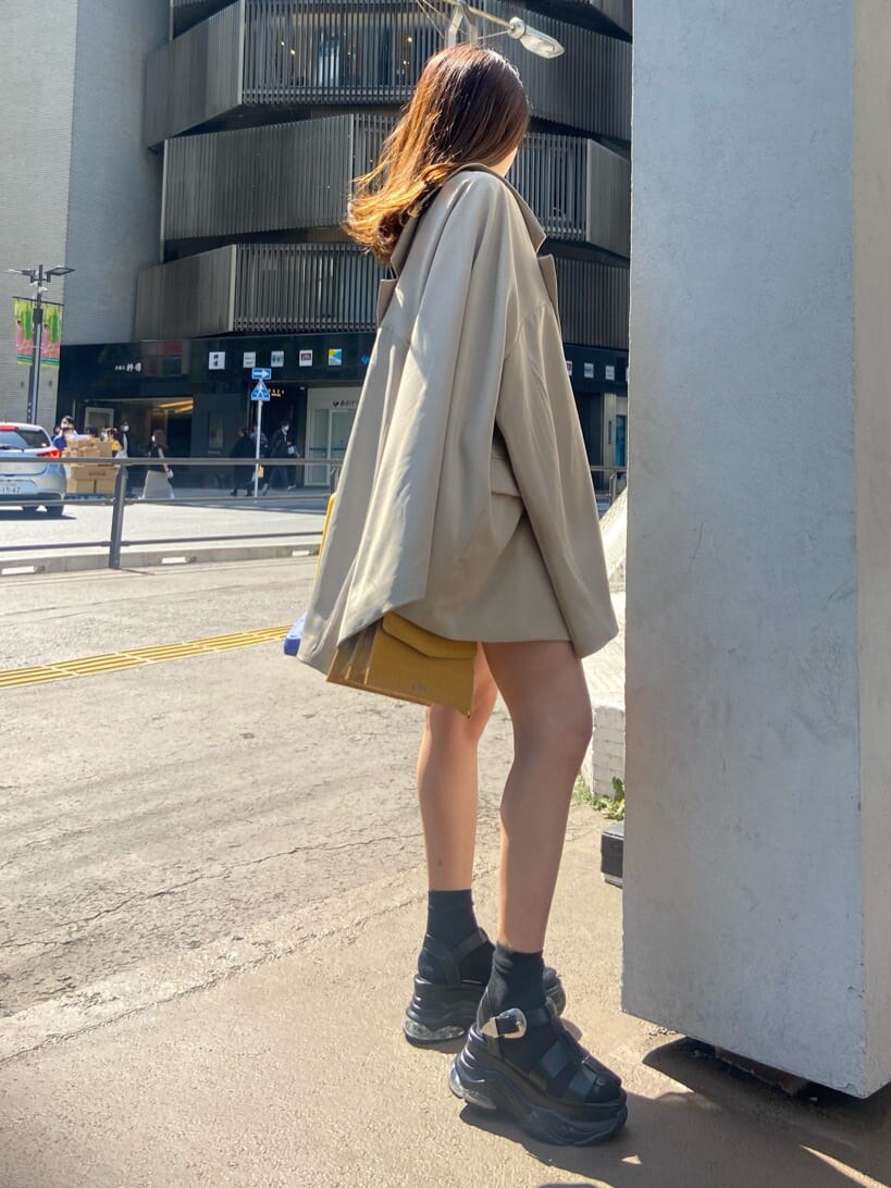 ベージュ系のテーラードジャケット、ブラック系のワンピース、ブラック系のサンダルを着用したレディースの春コーディネートの8枚目の写真